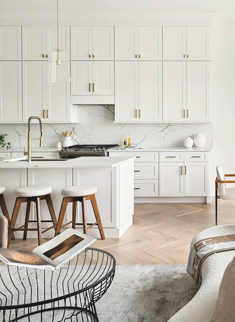 White shaker kitchen with marble backsplash and gold hardware